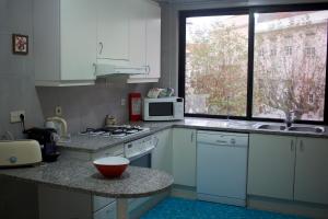 菲盖拉-达福什Casino Figueira Prime Apartment的厨房配有白色橱柜、微波炉和台面