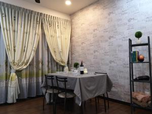 史里肯邦安Sweet Home Silk Sky Residence Balakong Seri Kembangan的用餐室配有桌椅和窗帘