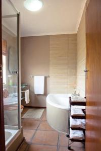 蒙塔古非洲格姆旅舍的带浴缸、淋浴和盥洗盆的浴室