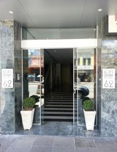阿雷格里港维德斯帕萨罗斯阁楼中心酒店的一座建筑的大厅,里面种植了两株盆栽植物