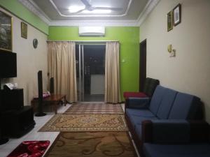 吉隆坡载哈公寓的客厅设有蓝色的沙发和绿色的墙壁。