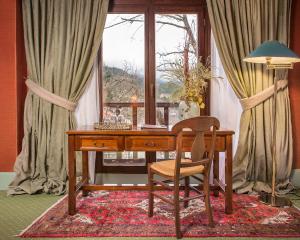米克隆科利奥Country Club Hotel & Suites的一张带椅子的木桌和一扇窗户