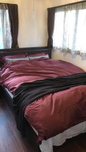 下关Guest House "Ro"kumano的卧室设有一张大床,设有两个窗户