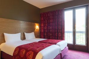 罗德兹Hôtel Tour Maje的酒店客房设有两张床和窗户。