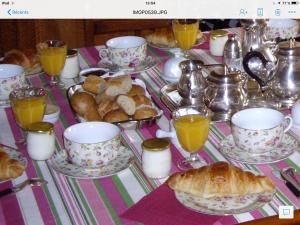 Vitry-aux-LogesLes Sapins的桌子,上面有杯子和盘子,有食物和面包