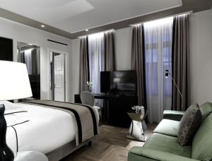 科斯镇Albergo Gelsomino的酒店客房配有床、沙发和电视。