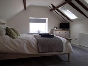 佩特沃斯The Cricketers Arms的一间卧室设有一张大床和一个窗户。