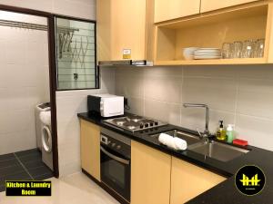 古晋Luco Apartments @ Imperial Suites Kuching的厨房配有炉灶、水槽和微波炉