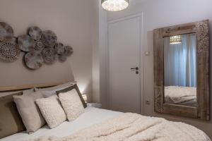 雅典Acropolis, Urban Lifestyle apartment的卧室配有一张壁挂镜子的床