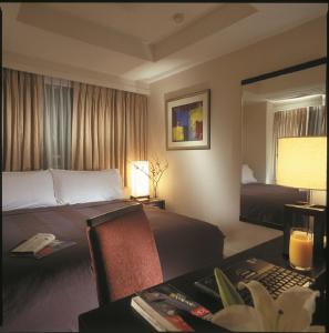 东京东京青山奥卓华庭酒店公寓的酒店客房配有两张床、一张书桌和一张书桌