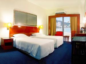 乔治市天堂沙滩度假村的酒店客房设有两张床和窗户。
