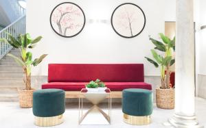 塞维利亚珀蒂帕拉斯圣克鲁斯酒店的红绿沙发,在盆栽的房间里