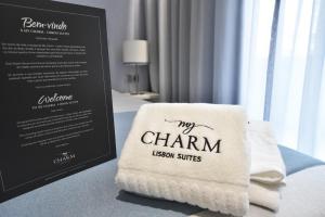 里斯本My Charm Lisbon Suites的坐在菜单旁的桌子上的毛巾