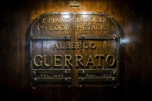 威尼斯Hotel Guerrato的木墙上的标志,上面写着