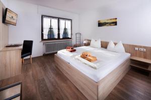 德罗尔斯哈根霍贝尔酒店的卧室配有一张白色大床和一把椅子