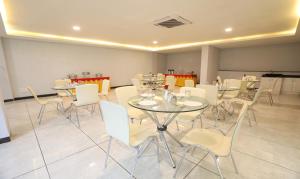 班加罗尔Treebo Trend Apple Villa的用餐室配有桌子和白色椅子