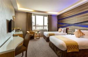 麦纳麦Al Safir Hotel的酒店客房设有两张床和电视。