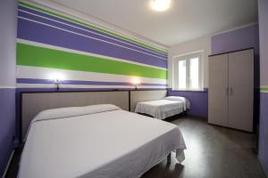 比萨泰拉诺瓦酒店的一间卧室设有两张床和彩色的墙壁
