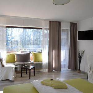 比勒费尔德瓦尔德比勒费尔德旅馆的带沙发和大窗户的客厅