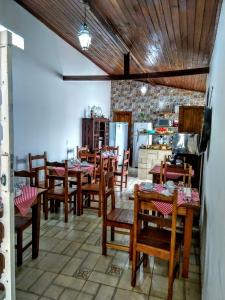 蒂拉登特斯Pousada Sinhá Vilaça的一间带木桌椅的用餐室和一间厨房