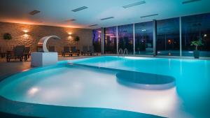 皮耶什佳尼公园酒店的一座蓝色灯光建筑中的一座大型游泳池