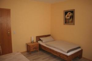 拉姆斯泰因-米森巴赫麦克拉酒店的卧室配有一张床,墙上挂着一幅画