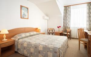 科斯特罗马科斯特洛马阿兹姆酒店的酒店客房带一张床、一张桌子和椅子