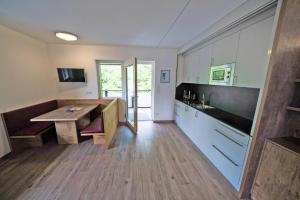 卡尔达罗Residence Tannhof的厨房铺有木地板,配有木桌。