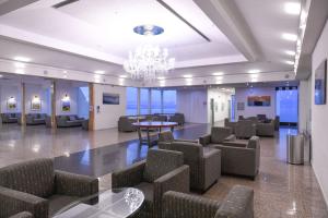 提比里亚Club Hotel Tiberias - Suites Hotel的大堂设有椅子、桌子和吊灯。