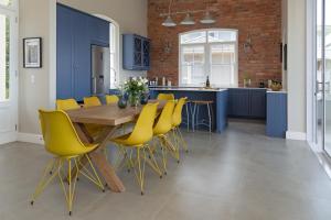 开普敦Le Vine Constantia的厨房配有木桌和黄色椅子