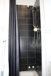 爱丁堡阿尔德米兰酒店的带淋浴的浴室和黑色瓷砖墙