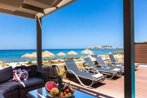 罗希姆诺Espera, Luxury Beach Front Residence, By ThinkVilla的一个带躺椅和海滩的庭院