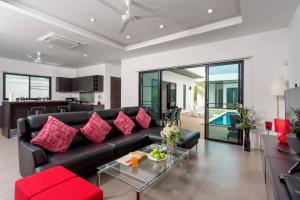 拉威海滩Villa Nc10的客厅配有黑色沙发和红色枕头