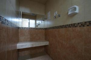 瓦曼特拉阿苏塞纳酒店的带淋浴、长凳和镜子的浴室