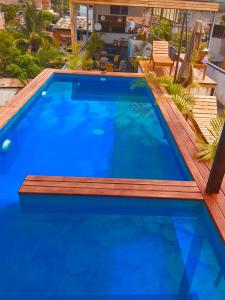 塔拉波托Hotel Central的一个带木甲板和蓝色海水的游泳池