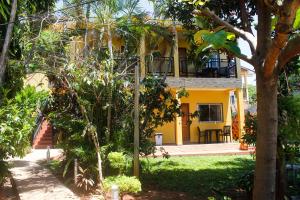 伊瓜苏港Hospedaje Jose Gorgues的带阳台的黄色房子,位于庭院内