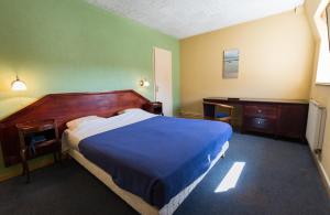 圣迪济耶尚巴尼酒店的一间卧室配有一张床、一张桌子和一张四柱床。