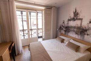 马德里Plaza Mayor Suites & Apartments的卧室设有一张白色大床和一扇窗户。