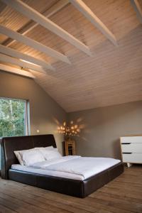 帕普帕普罗加斯山林小屋的一张位于带木制天花板的客房内的大床