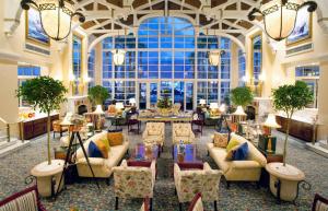 开普敦桌湾酒店 的大堂配有沙发和桌子,设有大窗户。