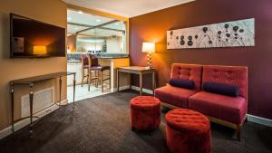 拉斯维加斯Best Western Plus Casino Royale - Center Strip的一间带红色沙发的客厅和一间酒吧