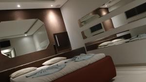 多拉杜斯Delirio Moteis Pousada的一间卧室配有两张床和镜子