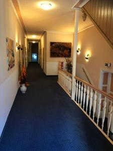 格里马Hotel Goldenes Schiff的走廊上,有楼梯,铺着蓝色地毯