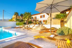 格里赞Villa In Verde的别墅设有带椅子和遮阳伞的游泳池