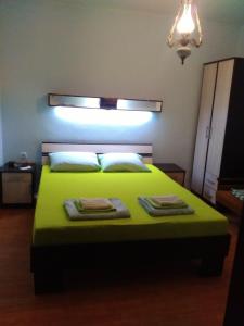 赫尔采格诺维Sobe Baosici Marina的一间卧室配有绿床和2条毛巾
