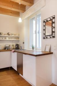 维也纳Sunny Apartments Vienna的厨房配有白色橱柜和木制台面