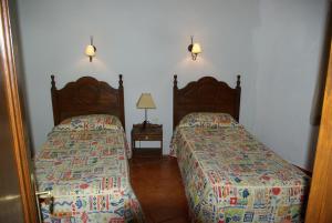 IsoraCasa Abuela María的一间卧室配有两张床和一张带台灯的桌子