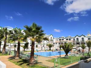 卡勒达德福斯特Estupendo Apartamento Gaudia的一个带游泳池和棕榈树的度假村