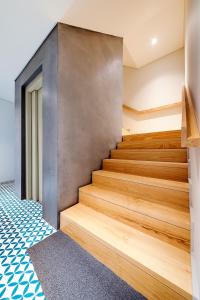 波尔图Bom Jardim Apartments的一座铺有木地板的房屋内的楼梯