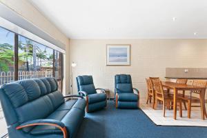 莱克斯恩特伦斯阿拉比假日公寓酒店的客厅配有蓝色的家具,用餐室
